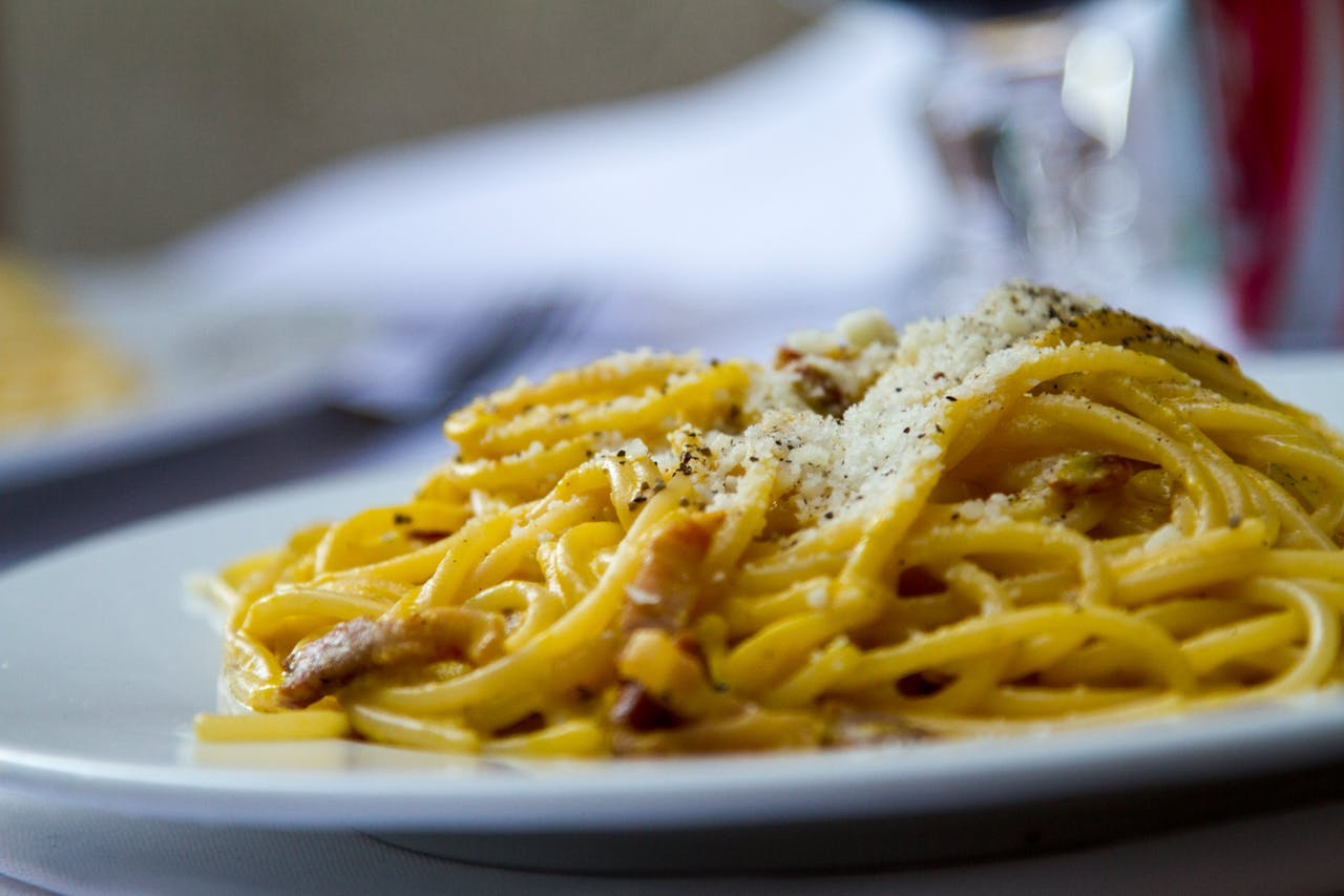 Crafting Captivating Headlines: Your awesome post title goes here Close-up of spaghetti carbonara topped with grated Parmesan cheese on a plate, perfect for Italian cuisine lovers.